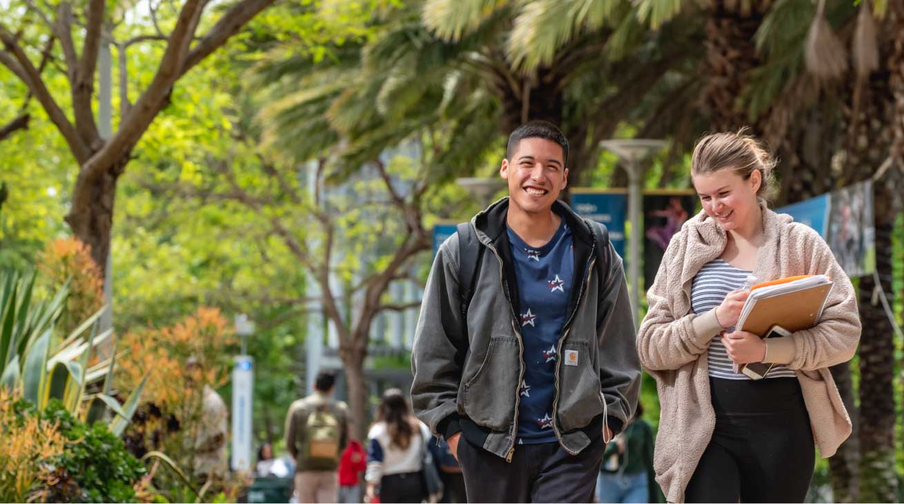 two students walking holding books