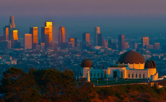 colorful sunset over round buildings at the top of a hill