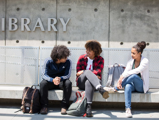 young people sit and chat on a concrete bench