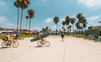 sidewalk filled with cyclists and surfers