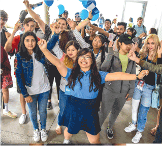 a group of happy smiling students with raised arms